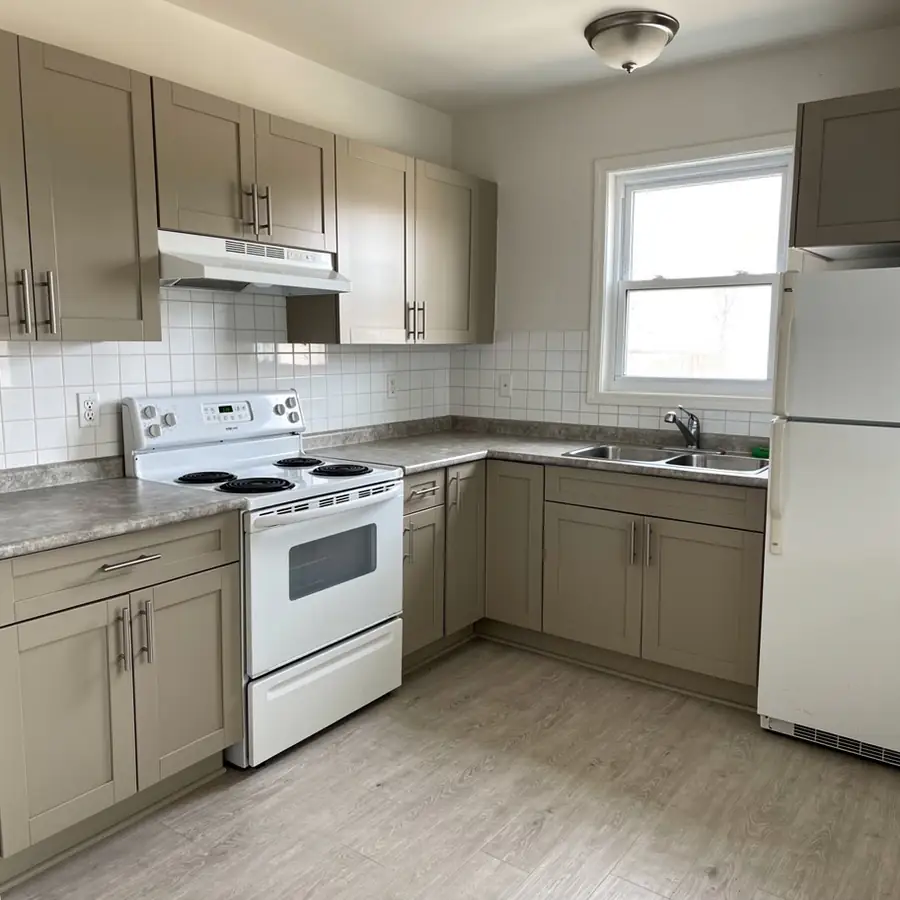 Greige painted rental apartment kitchen cabinets