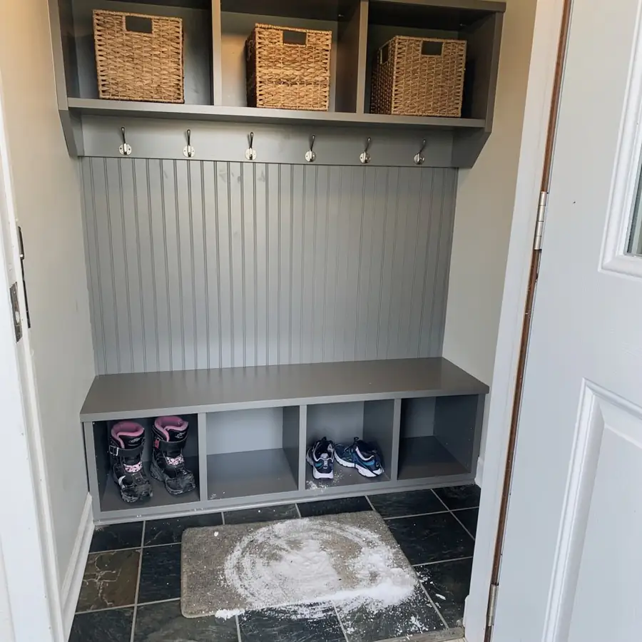 Grey painted entryway cubbies and boot storage