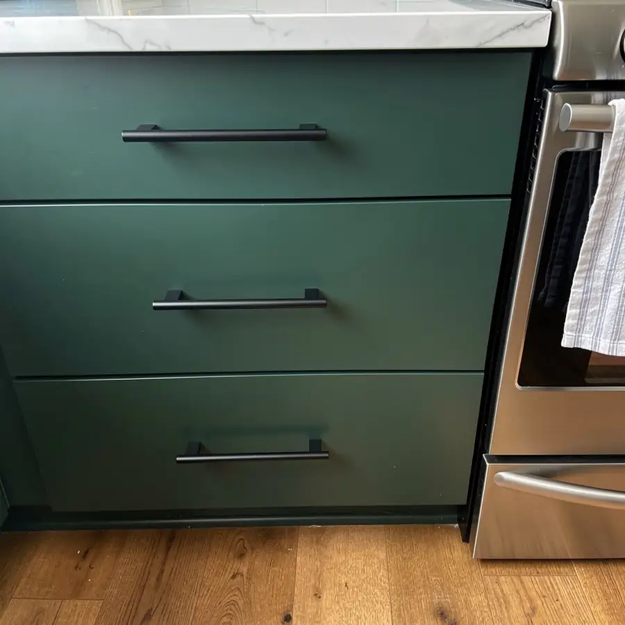Matte black pulls on forest green drawers