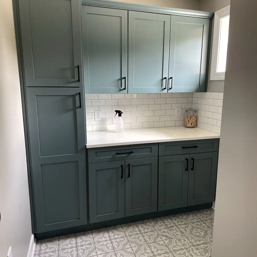 Muted teal laundry room cabinet bank
