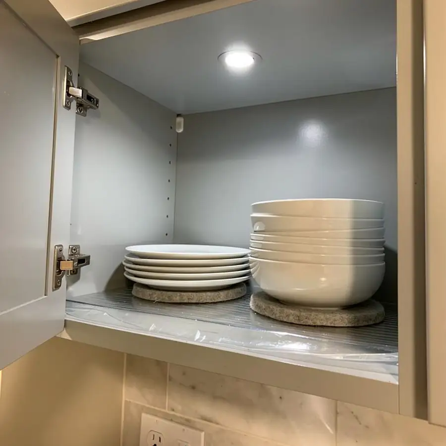 Plates on felt pads on painted shelf