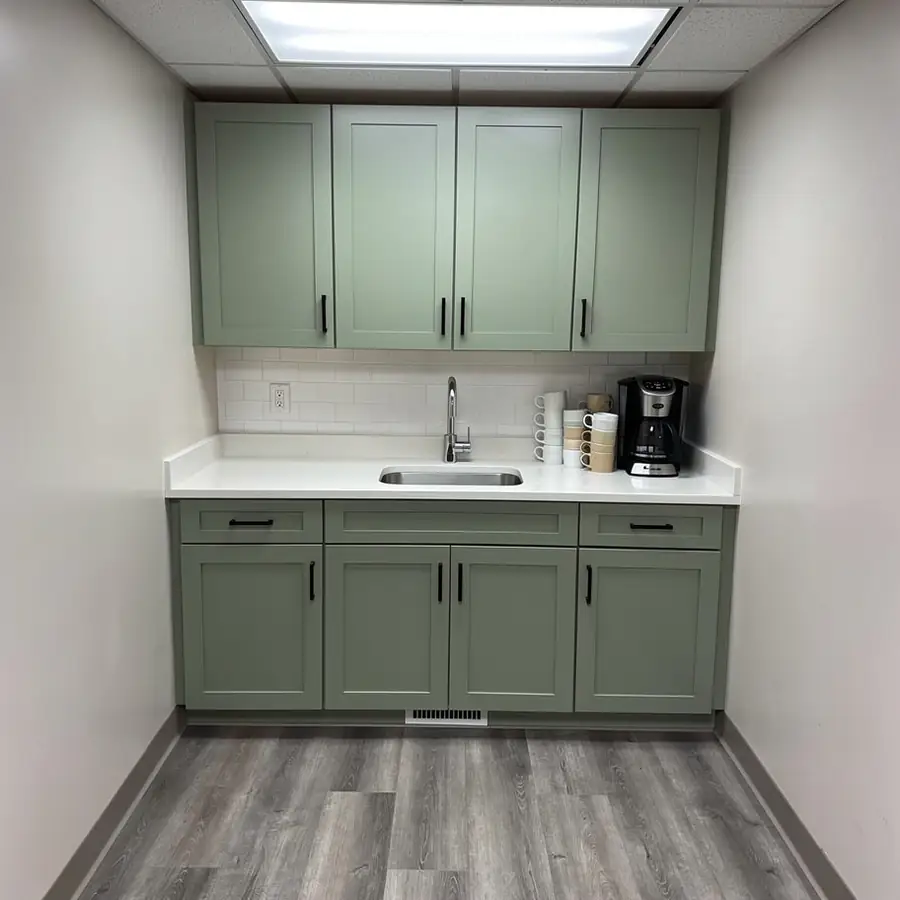 Sage green staff kitchenette cabinets in office