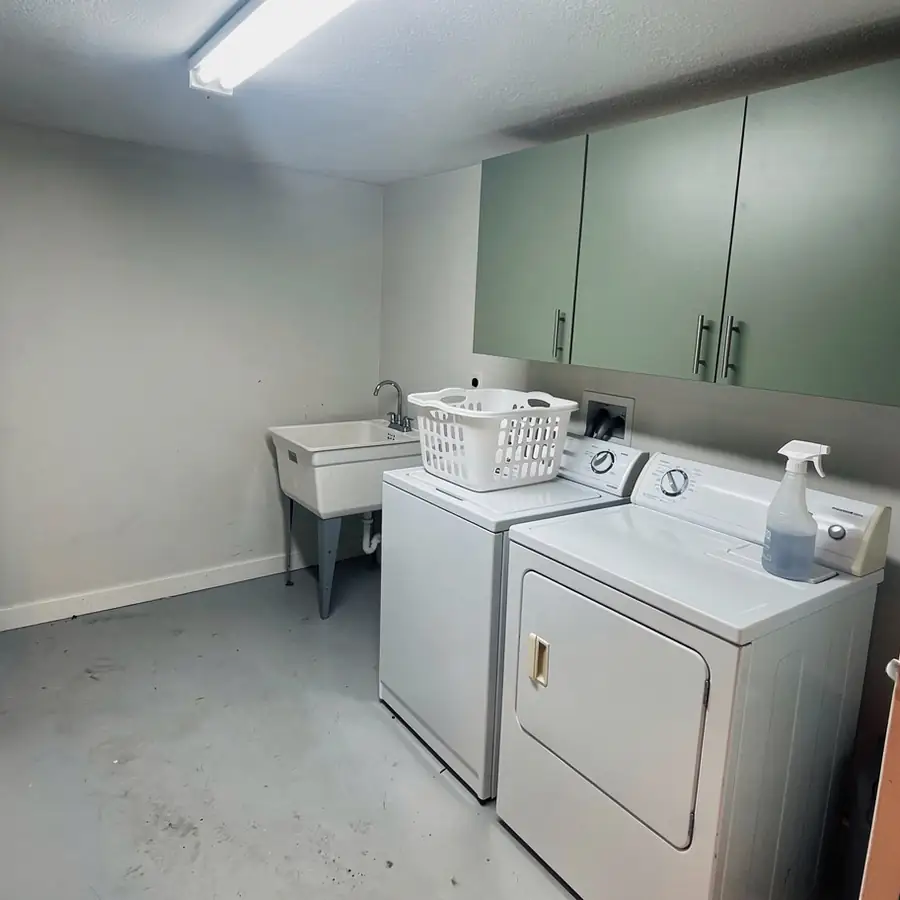 White melamine laundry cabinets painted sage green