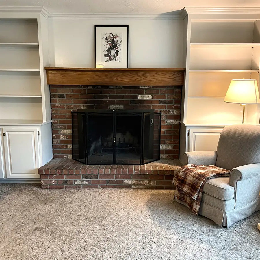 White painted oak mantel with brick fireplace